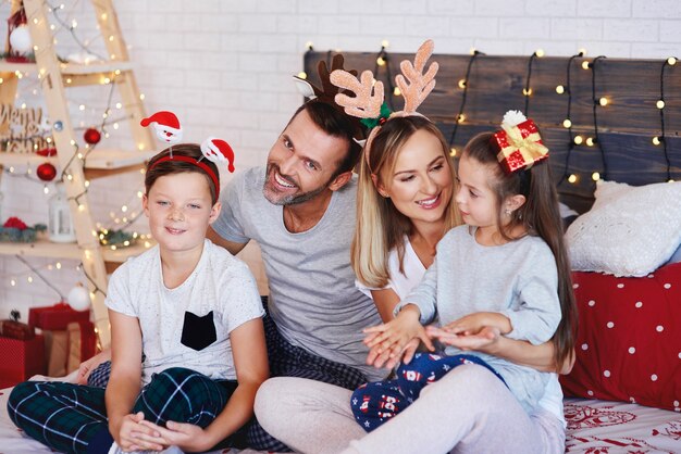 Family celebrating Christmas in bed