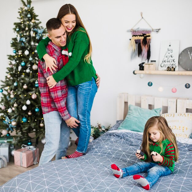 Family celebrating christmas together in bedroom