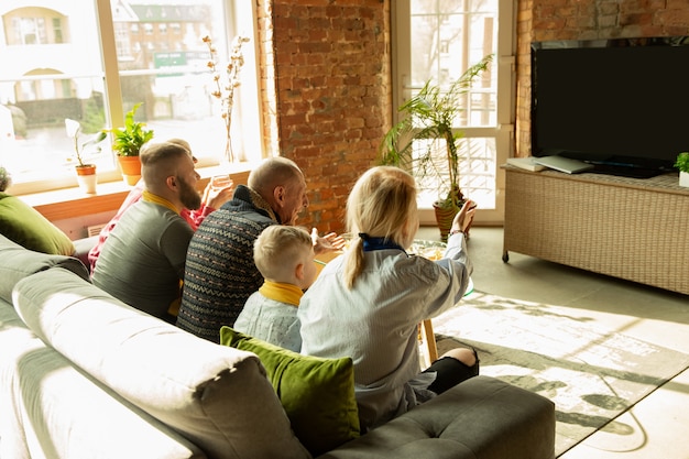 Family cheering and watchin tv at home in the living room