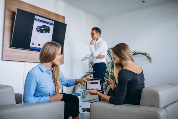 Famiglia che sceglie un'automobile in una sala d'esposizione dell'automobile