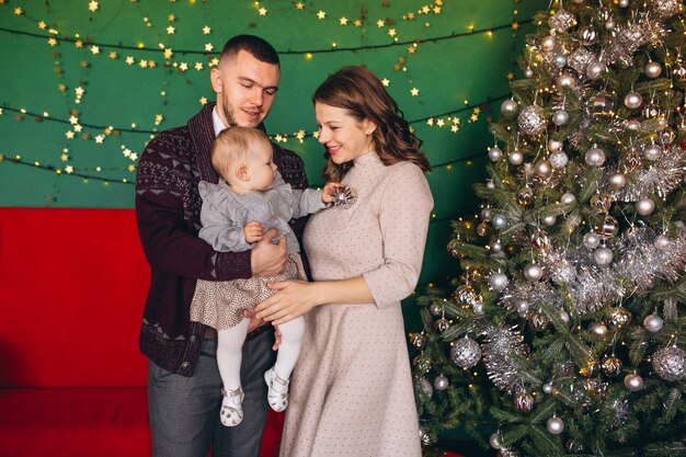 Free photo family on christmas by the christmas tree