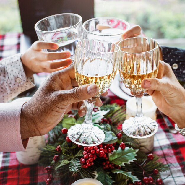 Family clinking with glasses at Christmas dinner table