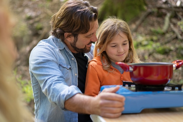 Family cooking in nature medium shot