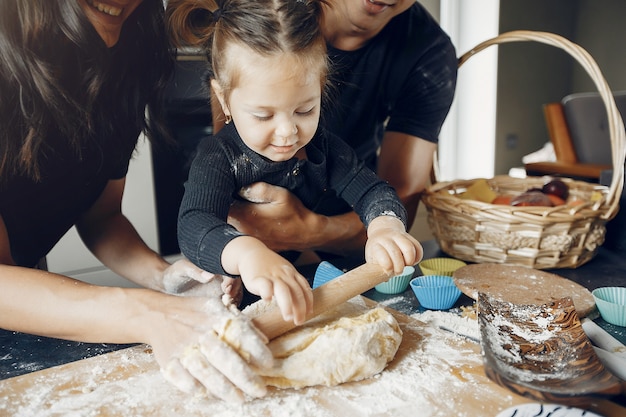 Family cooks the dough for cookies at the kitchen