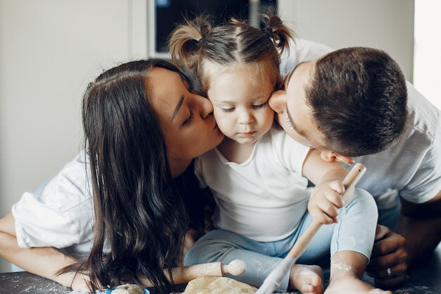 Family cooks the dough for cookies at the kitchen