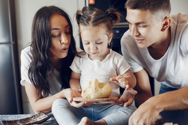 Family cooks the dough for cookies at the kitchen