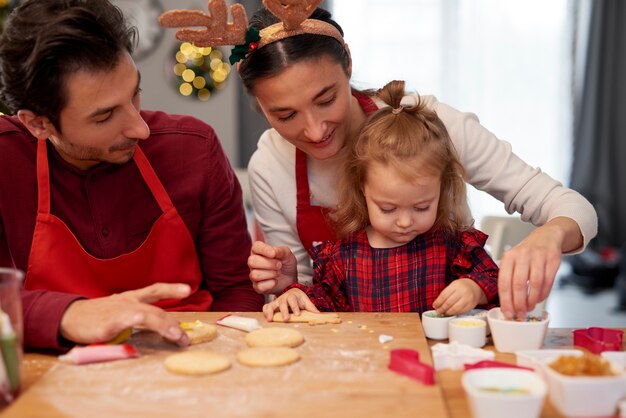 Family decorating Christmas cookies together in the kitchen