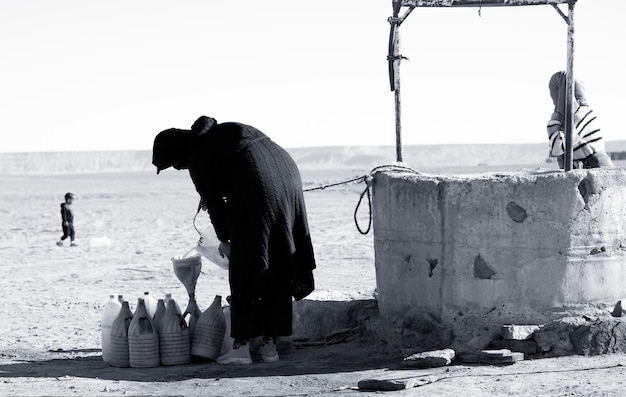 Free photo a family drawing water from a well in the desert of merzouga morocco