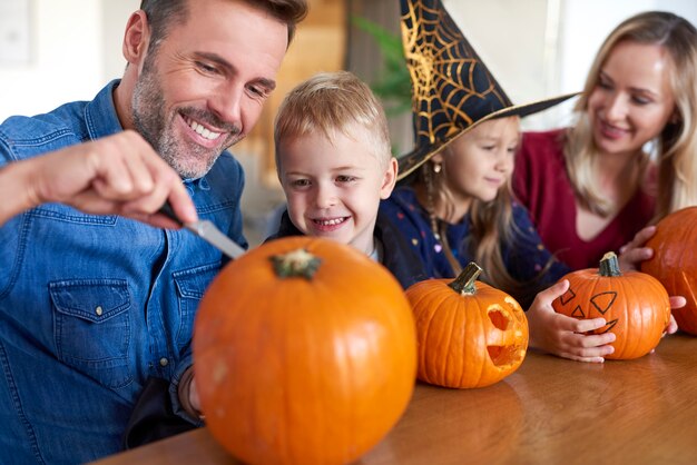 Family drilling pumpkins for Halloween