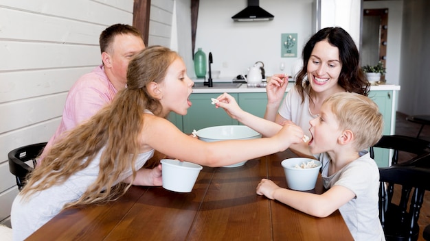 Famiglia che mangia popcorn al tavolo