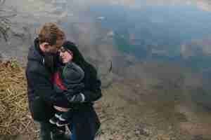 Foto gratuita famiglia che abbraccia allo stagno