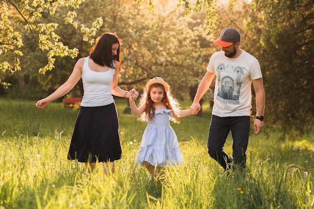 Family enjoying walk on green grass in park