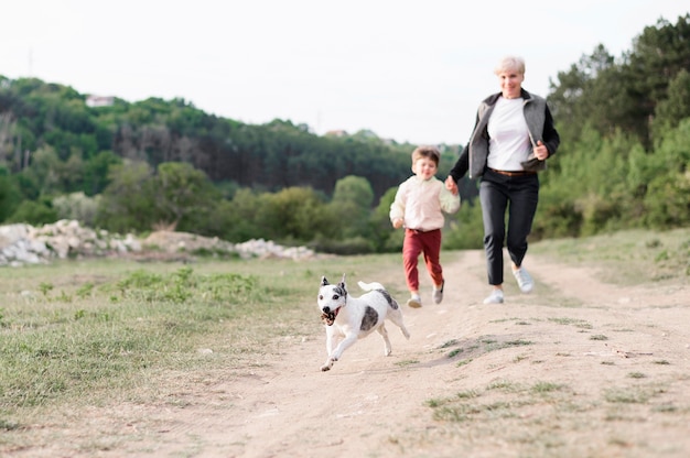 Family enjoying walk in the park with dog