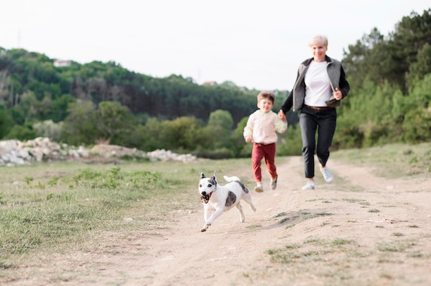 Семья наслаждается прогулкой в парке с собакой