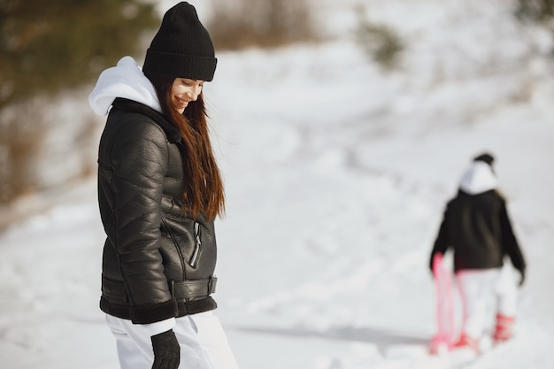 Family on family Christmas vacation. Woman and little girl in a forest. People walks.