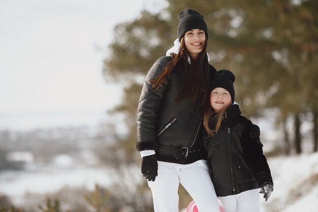 家族のクリスマス休暇中の家族。森の中の女性と少女。人々は歩きます。