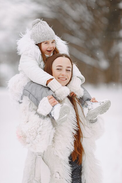 Family on family Christmas vacation. Woman and little girl in a park. People walks.