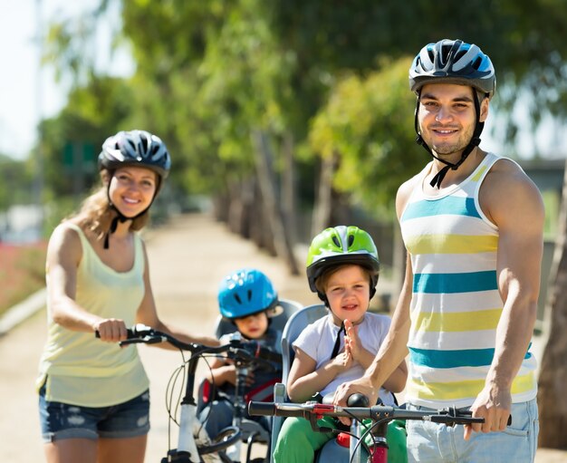 Family of four cycling on street