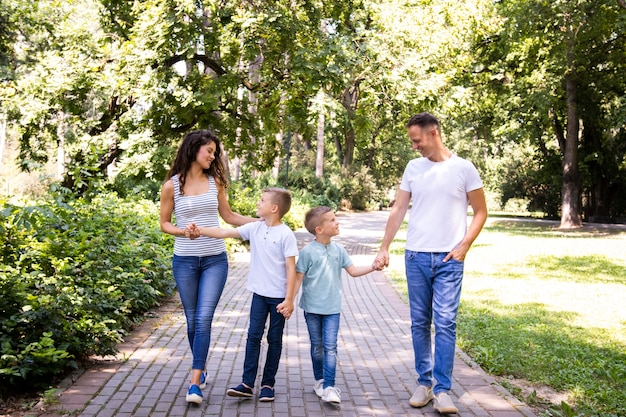Семья из четырех человек гуляет в парке