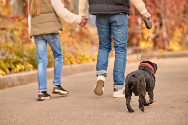 Foto gratuita una famiglia che va a spasso con un cane