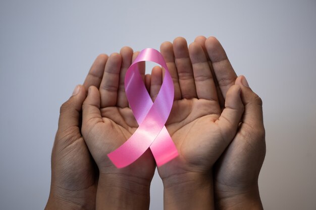 Family hand holding pink ribbon. concept healthcare and medicine, cancer concept