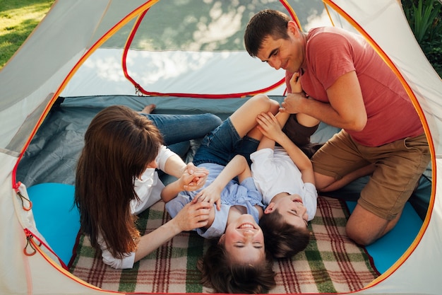 Семья весело в палатке на отдыхе в кемпинге