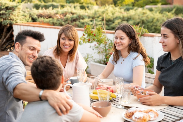 Foto gratuita famiglia che pranza insieme all'aperto