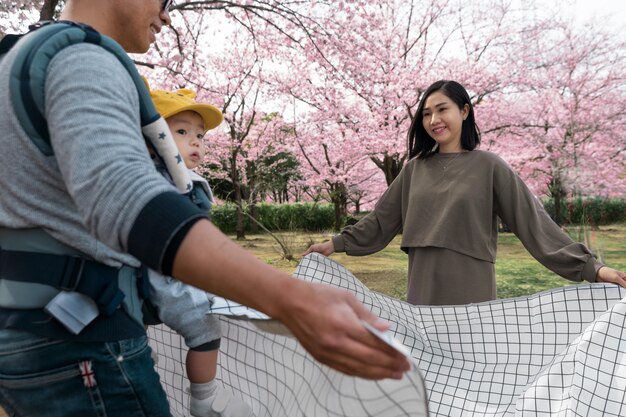 桜の横でピクニックをしている家族