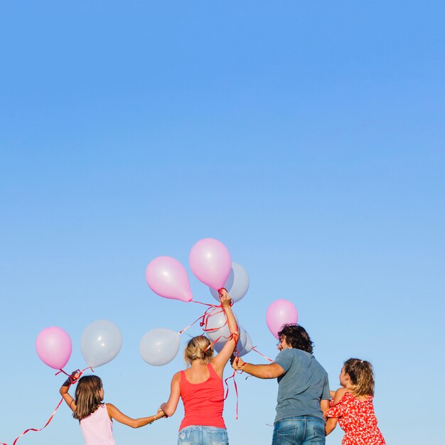 Family holding balloons over heads