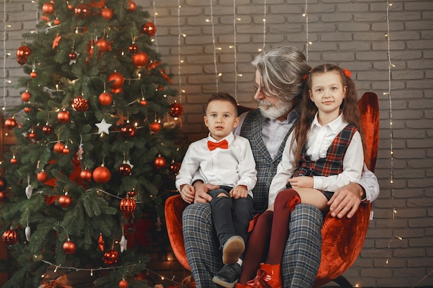 Family, holidays, generation, christmas and people concept . Children in a room decorated for Christmas