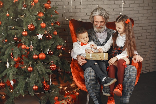 Family, holidays, generation, christmas and people concept . children in a room decorated for christmas