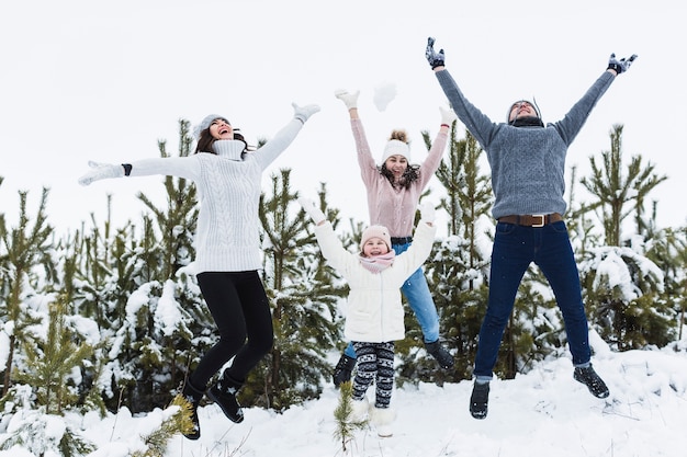 Family jumping near spruces