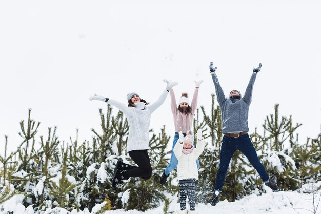 冬の森でジャンプする家族