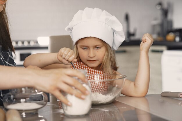 Family in a kitchen cook the dough for cookies