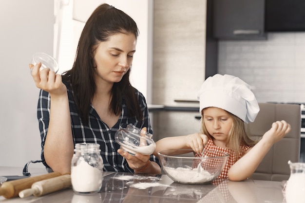 Family in a kitchen cook the dough for cookies