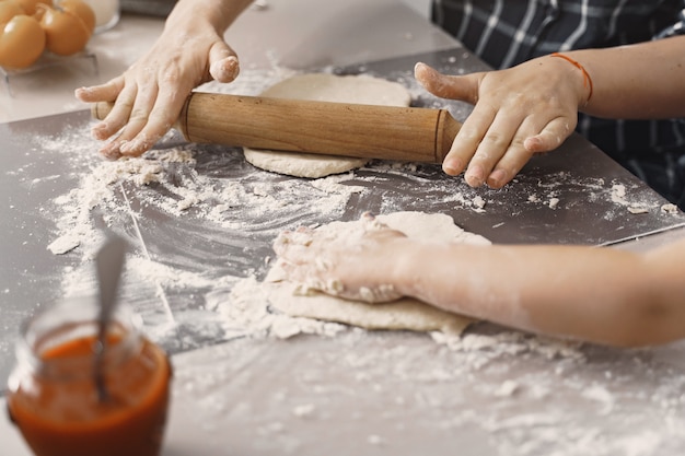 Family in a kitchen cook the dough for cookies