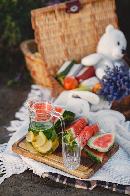 Family on lavender field. People on a picnic. Mother with children eats fruits.