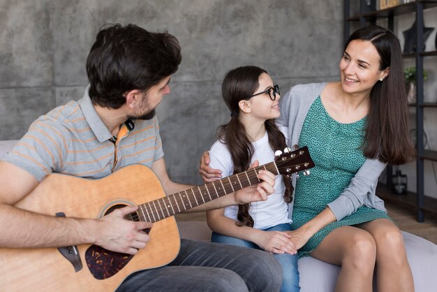 family learning to play guitar