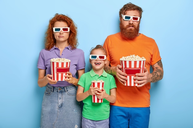 family members enjoy watching television with popcorn