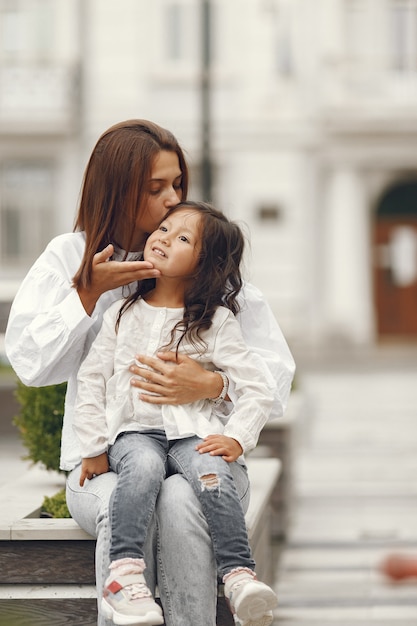 Famiglia vicino alla fontana della città. madre con la figlia che gioca con l'acqua.