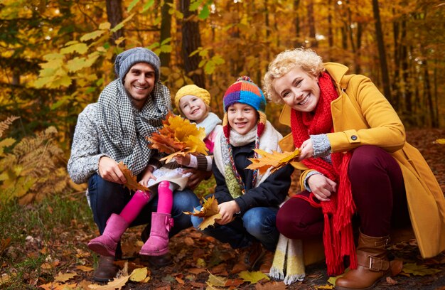 Family picking leafs on the fall season