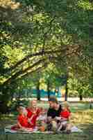 Foto gratuita famiglia che fa un picnic all'aperto con i loro bambini