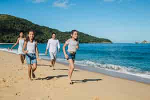 Free photo family playing and running on the beach