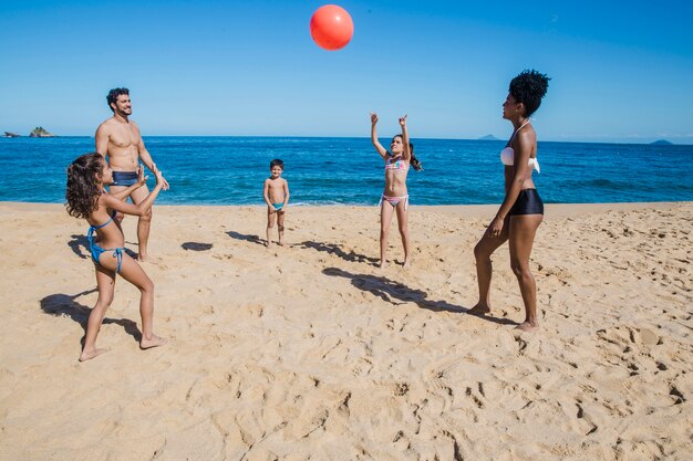 Family playing volley on the beach