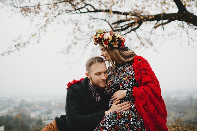 Family portrait, expacting couple. Man hugs tender pregnant woman