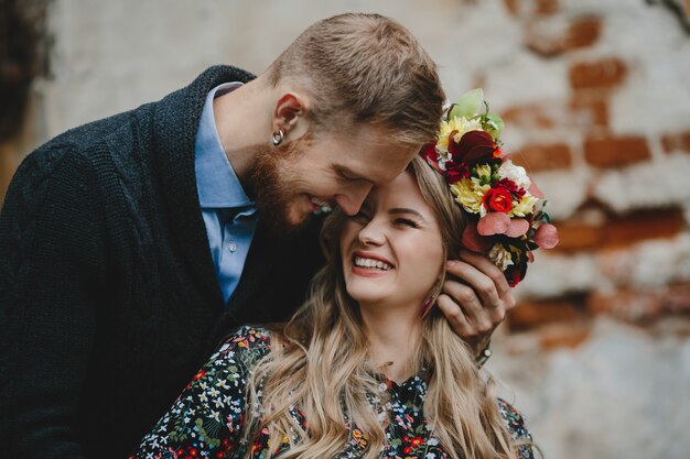 Family portrait, expacting couple. Man hugs tender pregnant woman