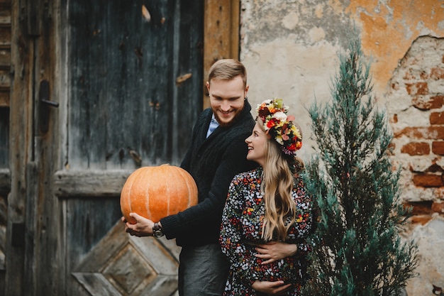 Family portrait, expacting couple. Man hugs tender pregnant woman