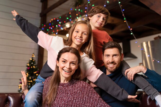 Family posing together next to a christmas tree