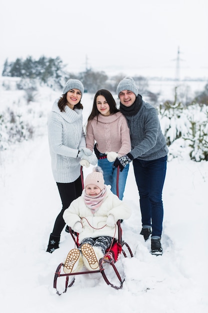 Family posing with sleigh