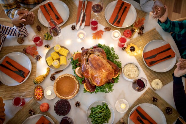 Family praying together before the thanksgiving day dinner